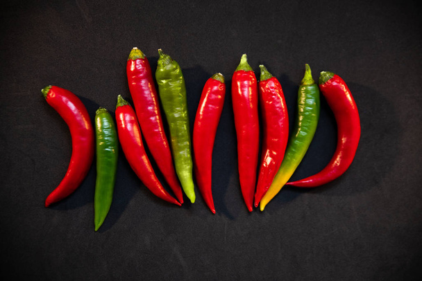 hot peppers on a black background - Фото, изображение