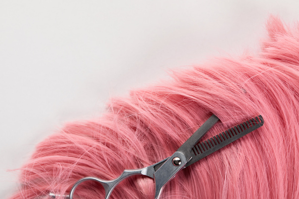 Top view of scissors on pink hair isolated on white - Photo, Image
