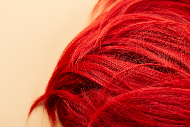 Вид сверху красных окрашенных волос на бежевом фоне
 - Фото, изображение