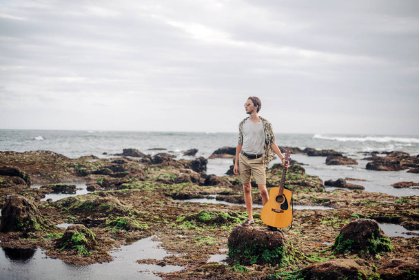 Romantico giovanotto con la chitarra sulla spiaggia - Foto, immagini