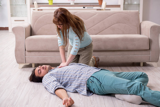 Young couple in first aid concept at home - Photo, Image