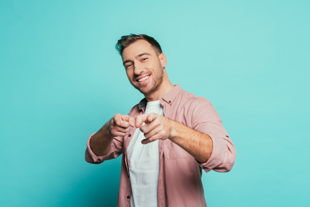 cheerful handsome man pointing at you, isolated on blue - Foto, Imagem