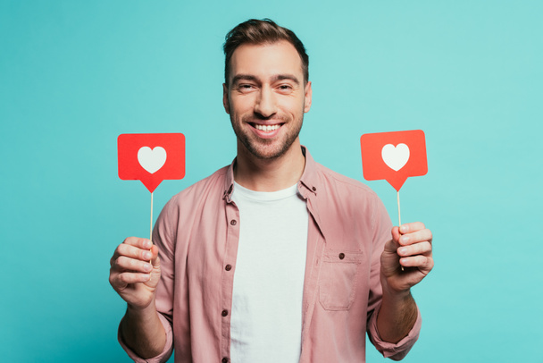 smiling man holding cards with hearts for valentines day, isolated on blue - Foto, immagini