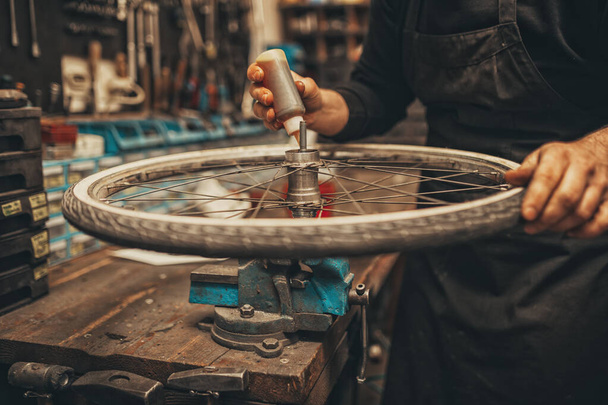 Tamir aşamasındaki bir atölyede bisiklet tamircisi. - Fotoğraf, Görsel