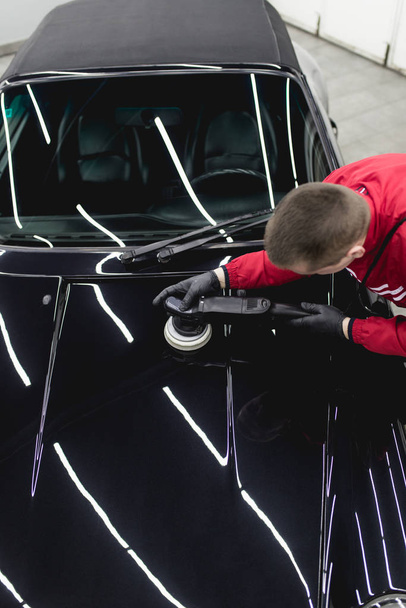 Detallado de coches, trabajador con pulidor orbital en taller de reparación de automóviles
.  - Foto, Imagen