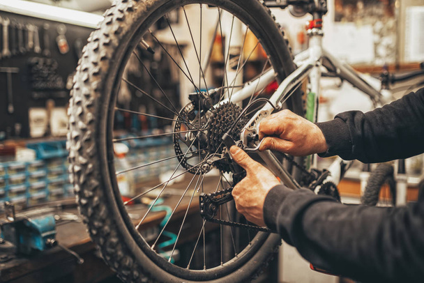 mecánico de bicicletas en un taller en el proceso de reparación. - Foto, Imagen