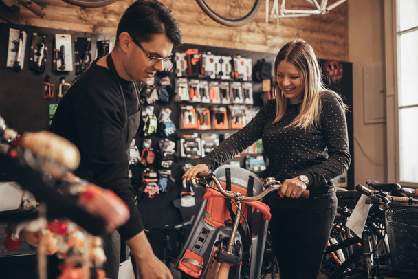 Young woman in bicycle shop choosing bike - Фото, зображення
