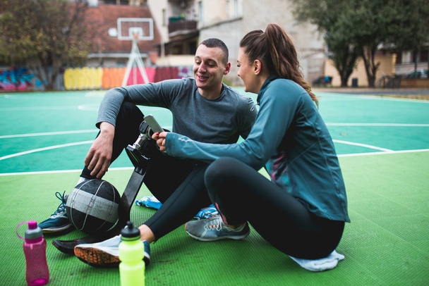 junger Mann mit Beinprothese genießt mit seinem Freund auf dem Basketballplatz. - Foto, Bild
