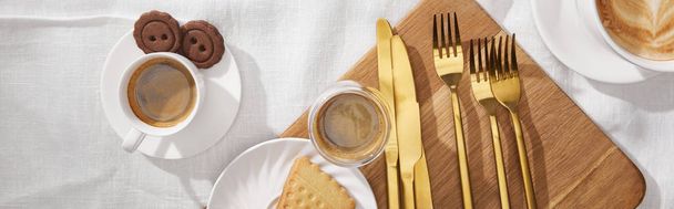 Top view of coffee and tasty cookies on chopping board on white cloth, panoramic shot - Photo, Image