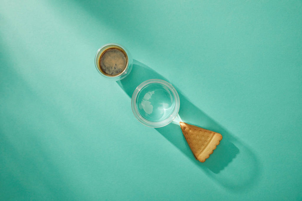 Top view of glasses of water and coffee with tasty cookie on turquoise background - Photo, Image