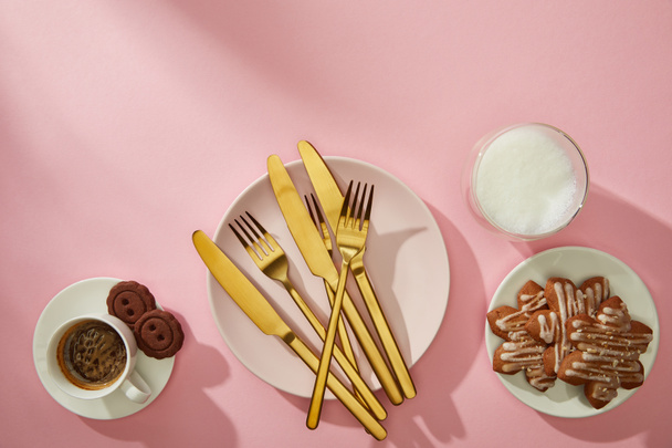 ピンクの背景にミルクとコーヒーとおいしいクッキーのトップビュー - 写真・画像