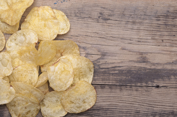 Group of potato chips close-up on wooden surface. - Fotoğraf, Görsel