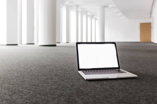 Photo of laptop on the floor in new empty office  - Photo, Image