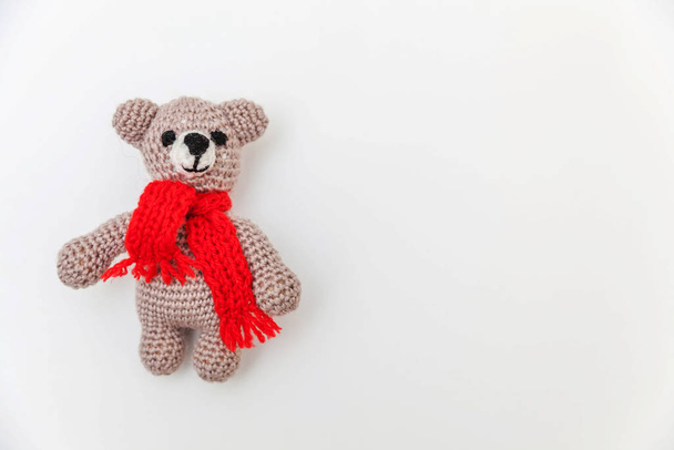 Design tout simplement minimal avec ours jouet en écharpe rouge isolé sur fond blanc. Les enfants prennent soin de la maternité concept familial. Pose plate, vue du dessus, espace de copie
 - Photo, image