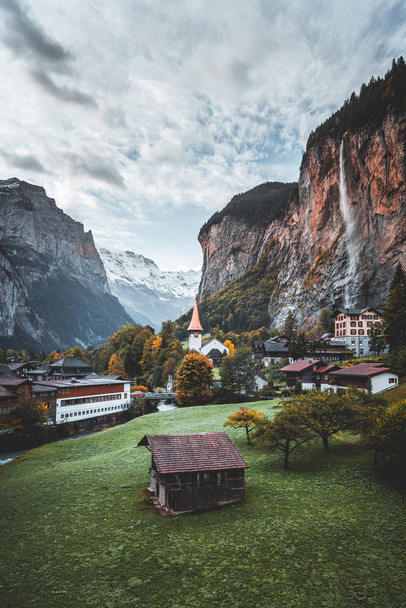 Increíble pueblo alpino turístico con famosa iglesia y cascada de Staubbach, Lauterbrunnen, Suiza, Europa - Foto, Imagen