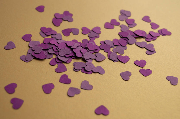 Kompozycja fioletowych serc na złotym tle na Walentynki 2020. Wakacyjny nastrój - Zdjęcie, obraz