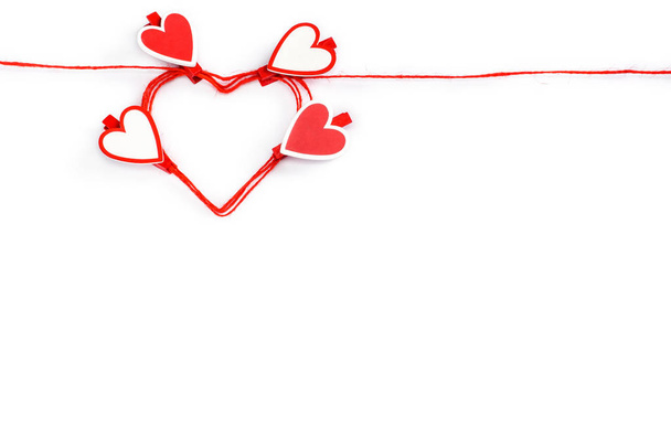 arrotolato a forma di cuore corda rossa con mollette a forma di cuore isolato su bianco. Concetto di San Valentino
. - Foto, immagini