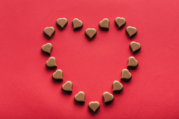 Heart shaped chocolates on red background for Valentine's day  - 写真・画像