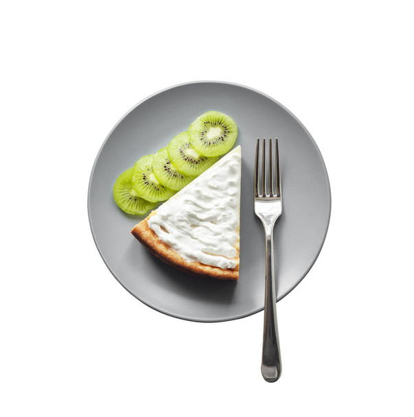 Homemade cottage cheese cake with kiwi fruit and cream on a plate - Photo, Image