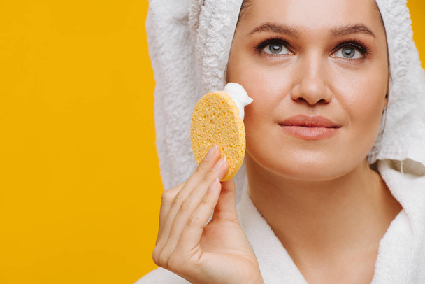 Sensual middle-aged woman applying moisturiser to her cheeks - Foto, Imagem