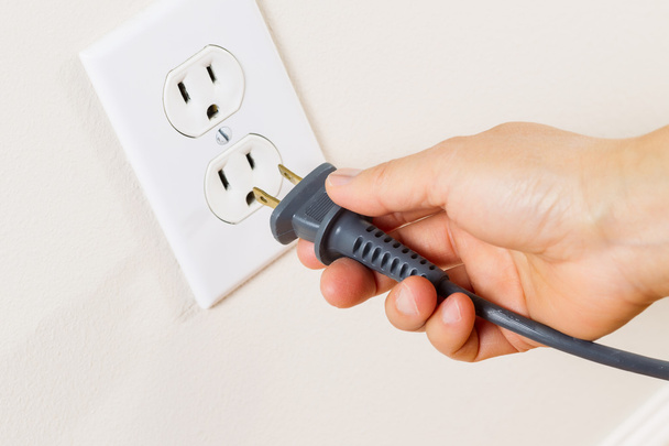 Inserting Power Cord Receptacle in wall outlet - Photo, image