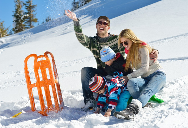 Famiglia che si diverte sulla neve fresca in vacanza invernale
 - Foto, immagini