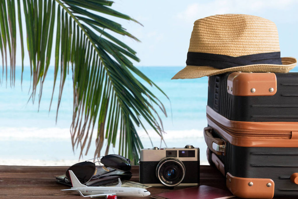 Summer travel and plan with vintage suitcase luggage and old camera in the sand beach. Travel in the holiday trips, airplane.  blue sky background. Summer and Travel Concept - Photo, Image