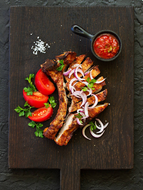 Pork chop on the bone with tomato sauce. view from above. - Фото, зображення