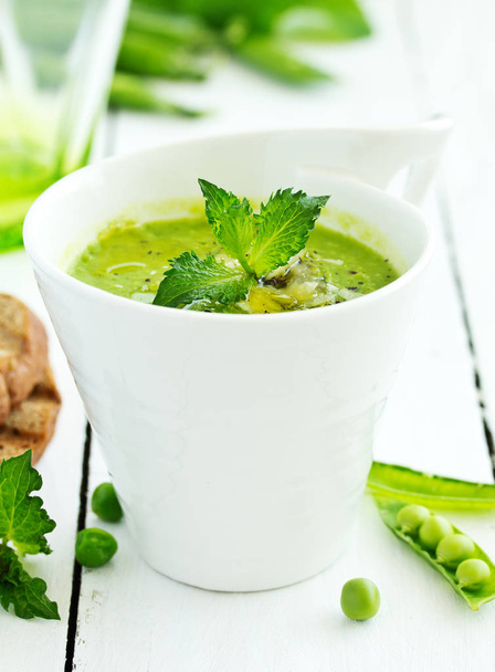 Green pea soup with croutons on wooden rustic background - Foto, Bild