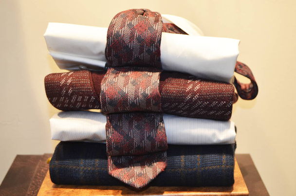 Koszula, sweter i krawat złożone w rzędzie. - Zdjęcie, obraz