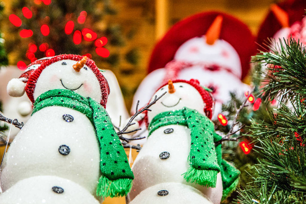 Compras navideñas. Interior de la tienda con luces de Navidad y grupo de muñeco de nieve en venta
.  - Foto, imagen
