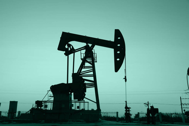 In the evening, the silhouette of the oil pump - Photo, Image