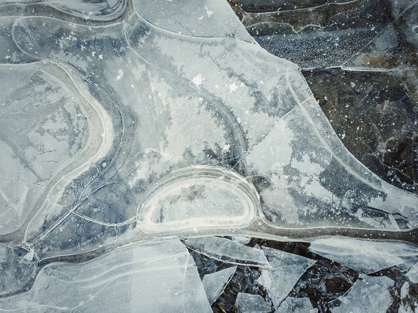 Κοντινό αφηρημένο φόντο μιας παγωμένης λιμνούλας. Σπασμένη λακκούβα - Φωτογραφία, εικόνα