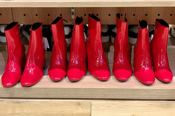 Kırmızı kadınların yüksek topuklu çizmeleri. Ayakkabıcıda parlak kadın ayakkabıları. Kadınlar için şık ayakkabılar.. - Fotoğraf, Görsel