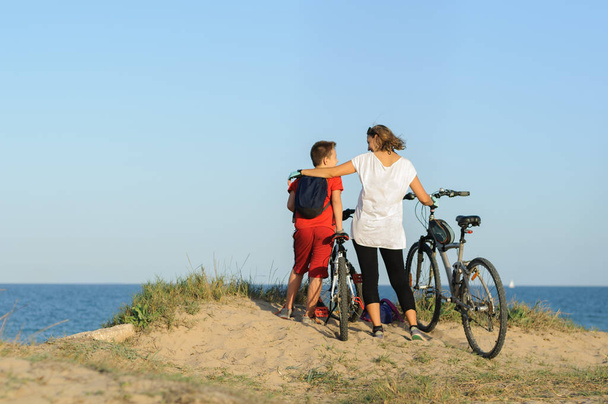 ragazzo e giovane donna su una bicicletta su una scogliera vicino al mare
 - Foto, immagini