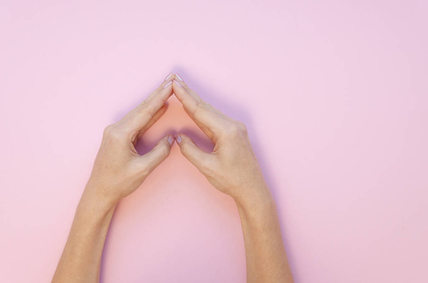 Flat lay love concept. Woman hands making a heart shape on a romantic Valentine pink background - Photo, Image