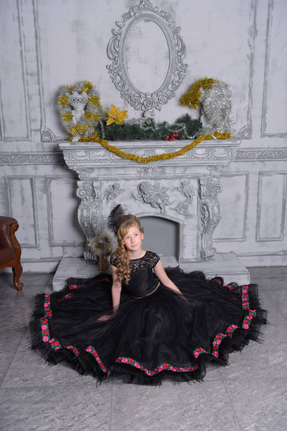 girl in elegant black dress is sitting in the gray - Foto, Imagen