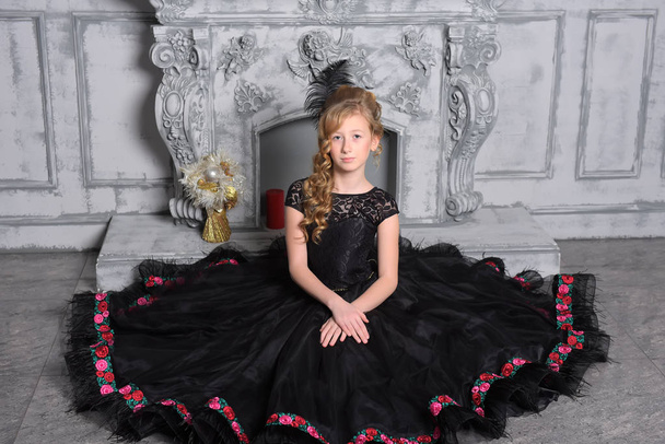 girl in elegant black dress is sitting in the gray - Foto, Imagen