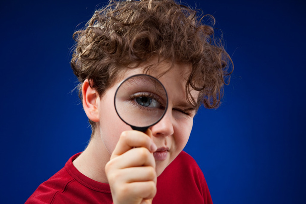 Boy using magnifying glass - Fotó, kép