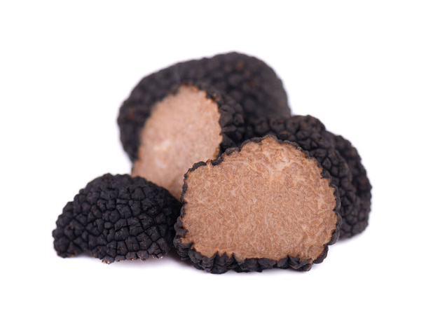 Black truffles isolated on a white background. Fresh sliced truffle. Delicacy exclusive truffle mushroom. Piquant and fragrant French delicacy. Clipping path. - 写真・画像