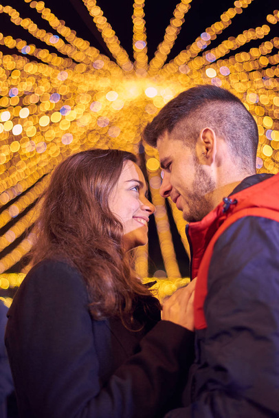 Jovem casal desfrutando de luzes de Natal
 - Foto, Imagem