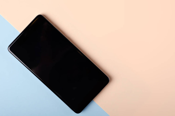 Black mobile phone composition on colored background. Flat lay. - Foto, Bild