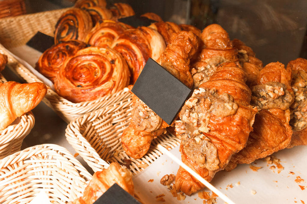 leckeres frisch gebackenes Gebäck in einer Konditorei. viele Brötchen und Croissants im Regal einer Backstube - Foto, Bild