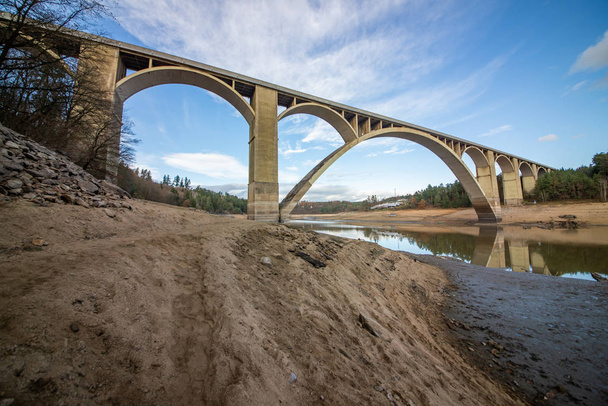 Le pont a été construit entre 1939 et 1943 pour remplacer l'ancien pont à chaînes construit en 1848. Ce pont a été démantelé en 1960 dans le cadre de la construction du réservoir Orlk et déplacé à la rivière Lunice
 - Photo, image