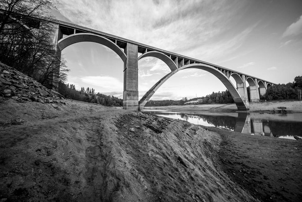 Most został zbudowany w latach 1939-1943, aby zastąpić stary most łańcuchowy zbudowany w 1848 roku. Most ten został rozebrany w 1960 roku w związku z budową zbiornika wodnego Orlk i przeniesiony do rzeki Lunice. - Zdjęcie, obraz