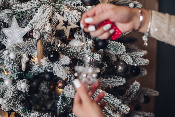 木の上にクリスマスのおもちゃを置く女性 - 写真・画像