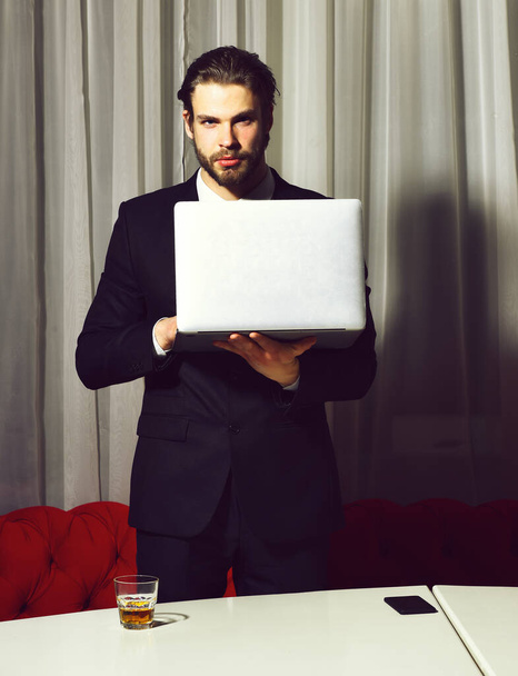 bearded man, businessman with glass of whiskey, cell phone, laptop - Fotografie, Obrázek