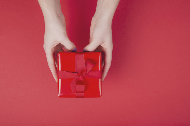 Woman's hands holding red gift box - Foto, imagen