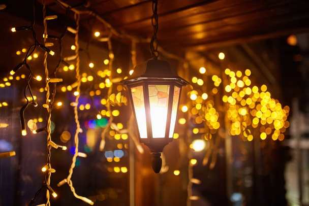 Старинный уличный фонарь в старинном стиле ночью с рождественскими украшениями
. - Фото, изображение