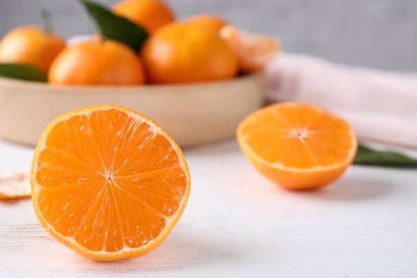 Cut fresh ripe tangerines on white wooden table - Foto, Bild